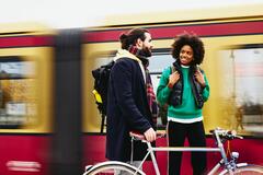 Mand med cykel og smilende kvinde foran et tog