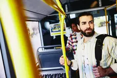 male standing in bus.
