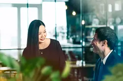 male and female talking and smiling.
