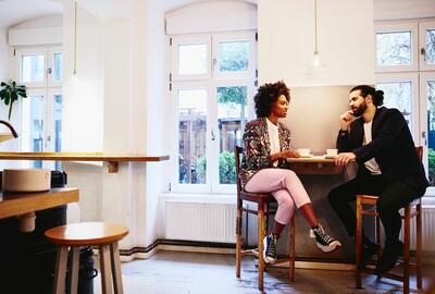 Mand og kvinde som sidder sammen på en cafe