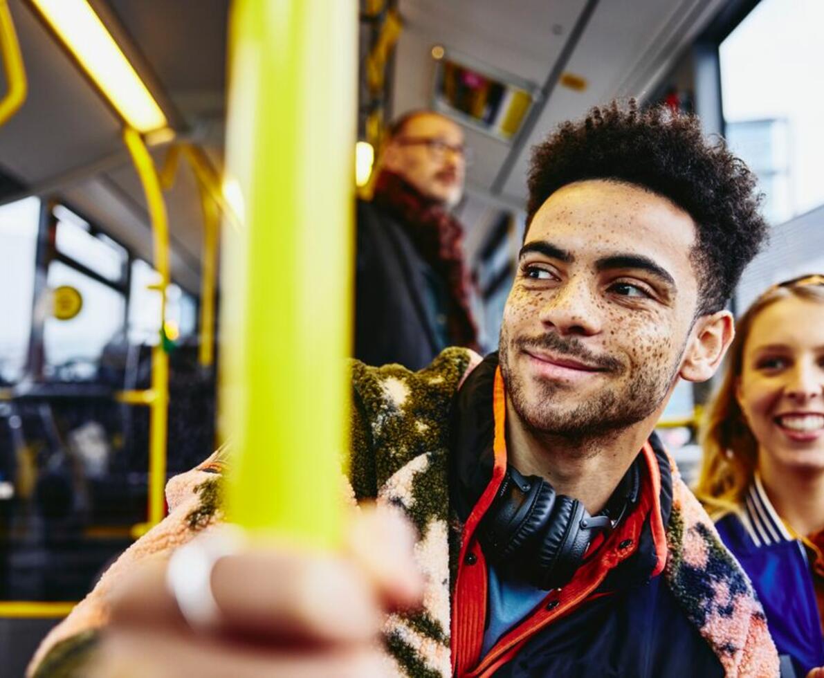 two friends sitting on a bus smiling
