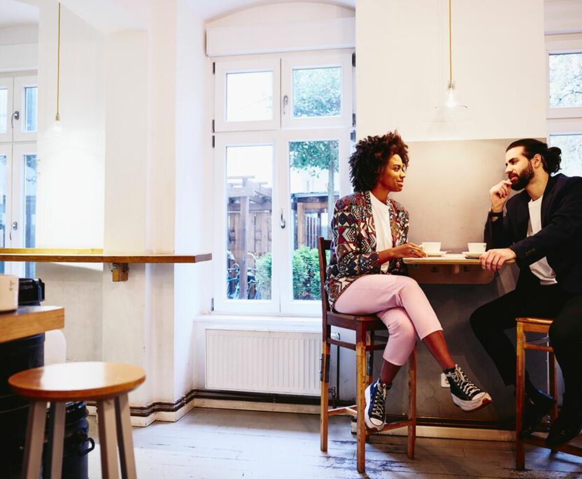 Mand og kvinde som sidder sammen på en cafe