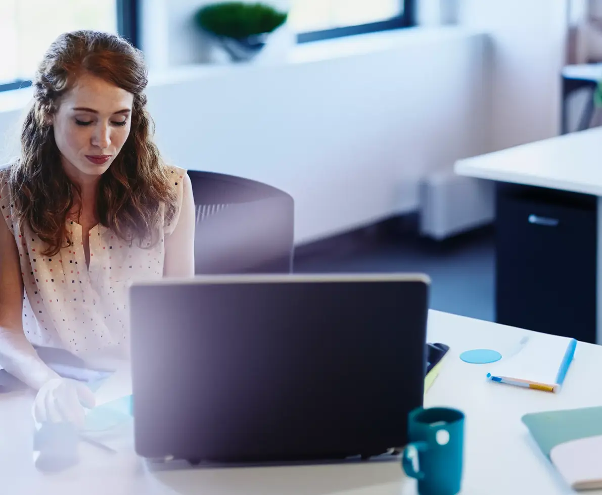 Womale sitting at a desk behind a laptopRandstad Human Forward