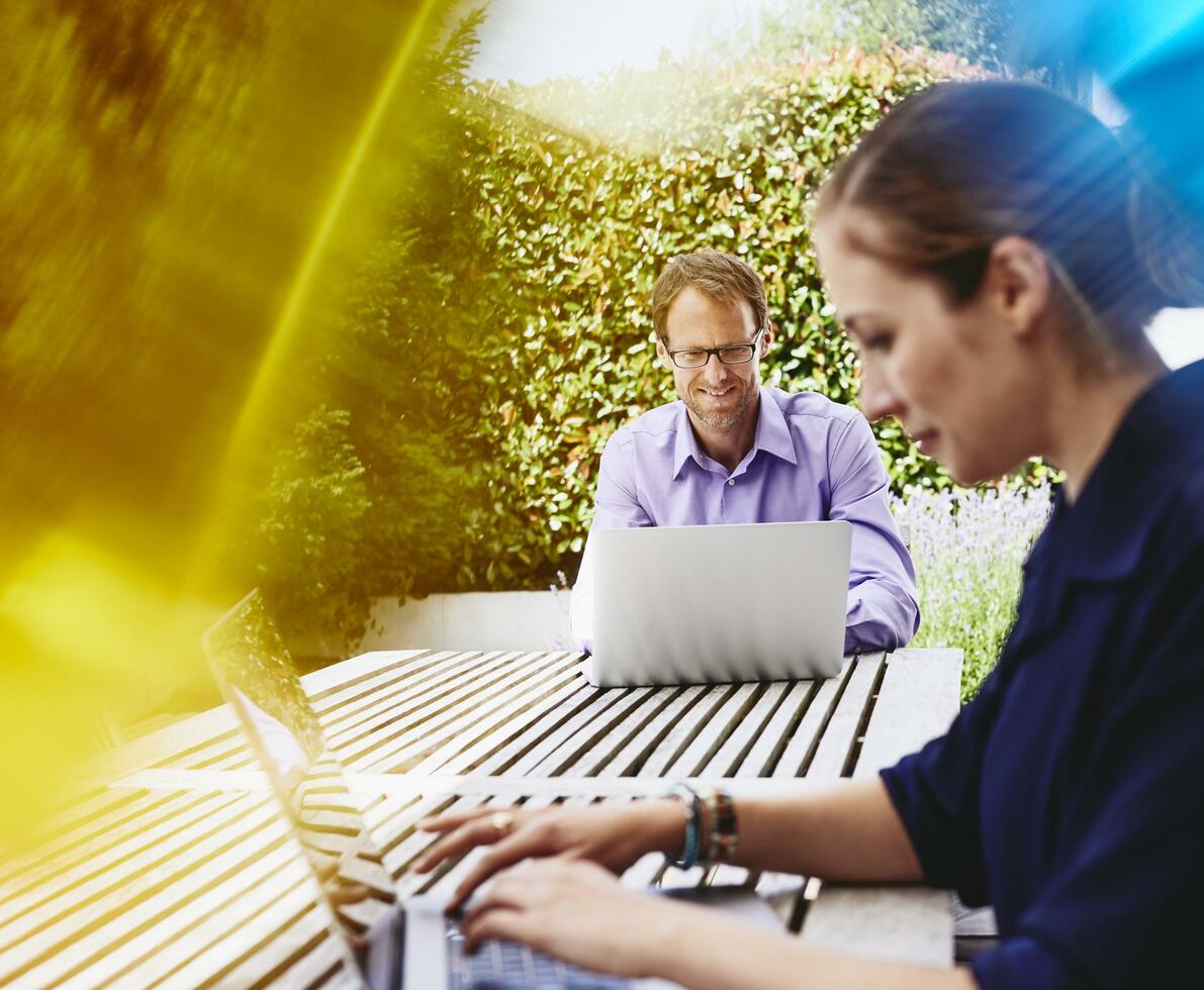 2 peope writing on a computer