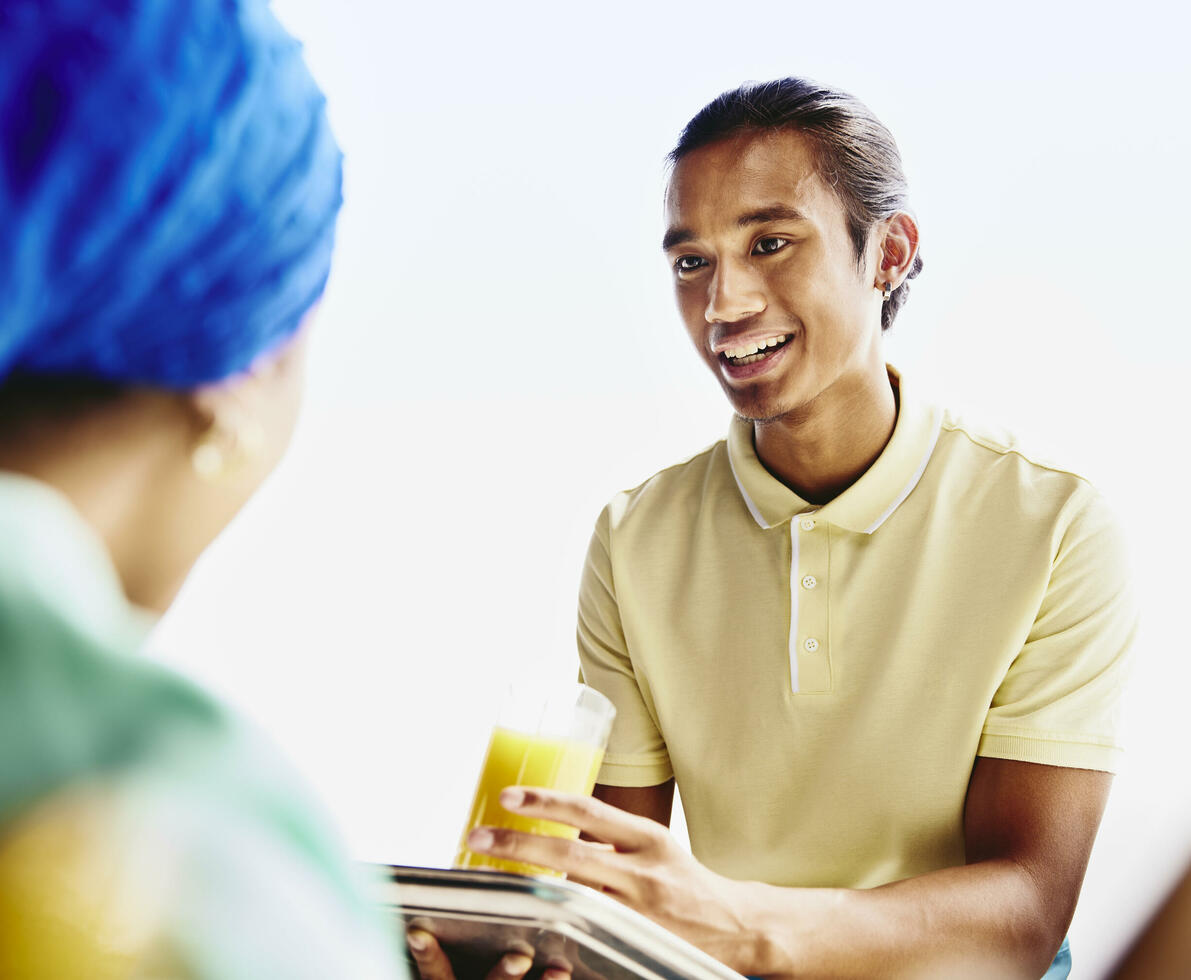 Waiter serving a drink to a woman.