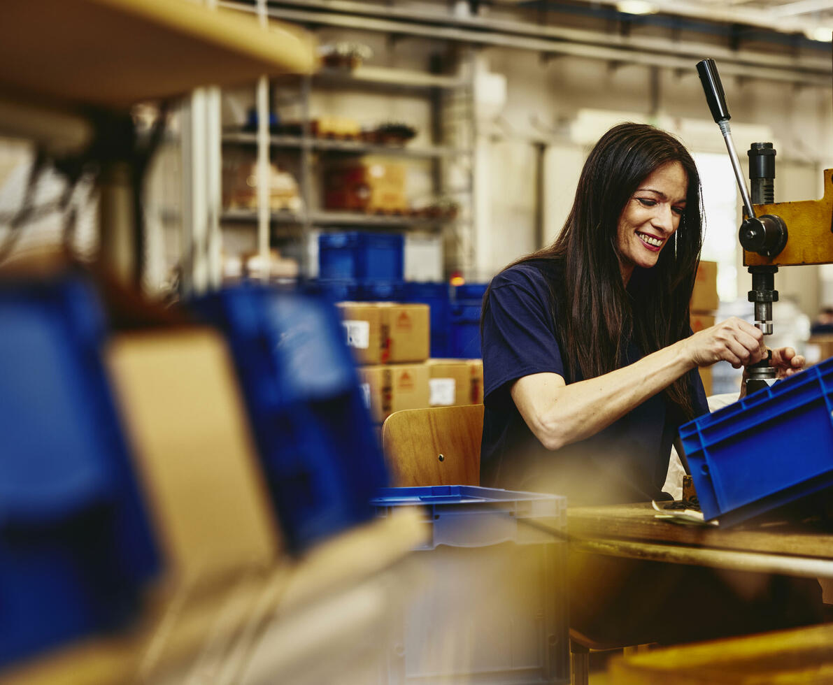 Smiling woman working on a production site.