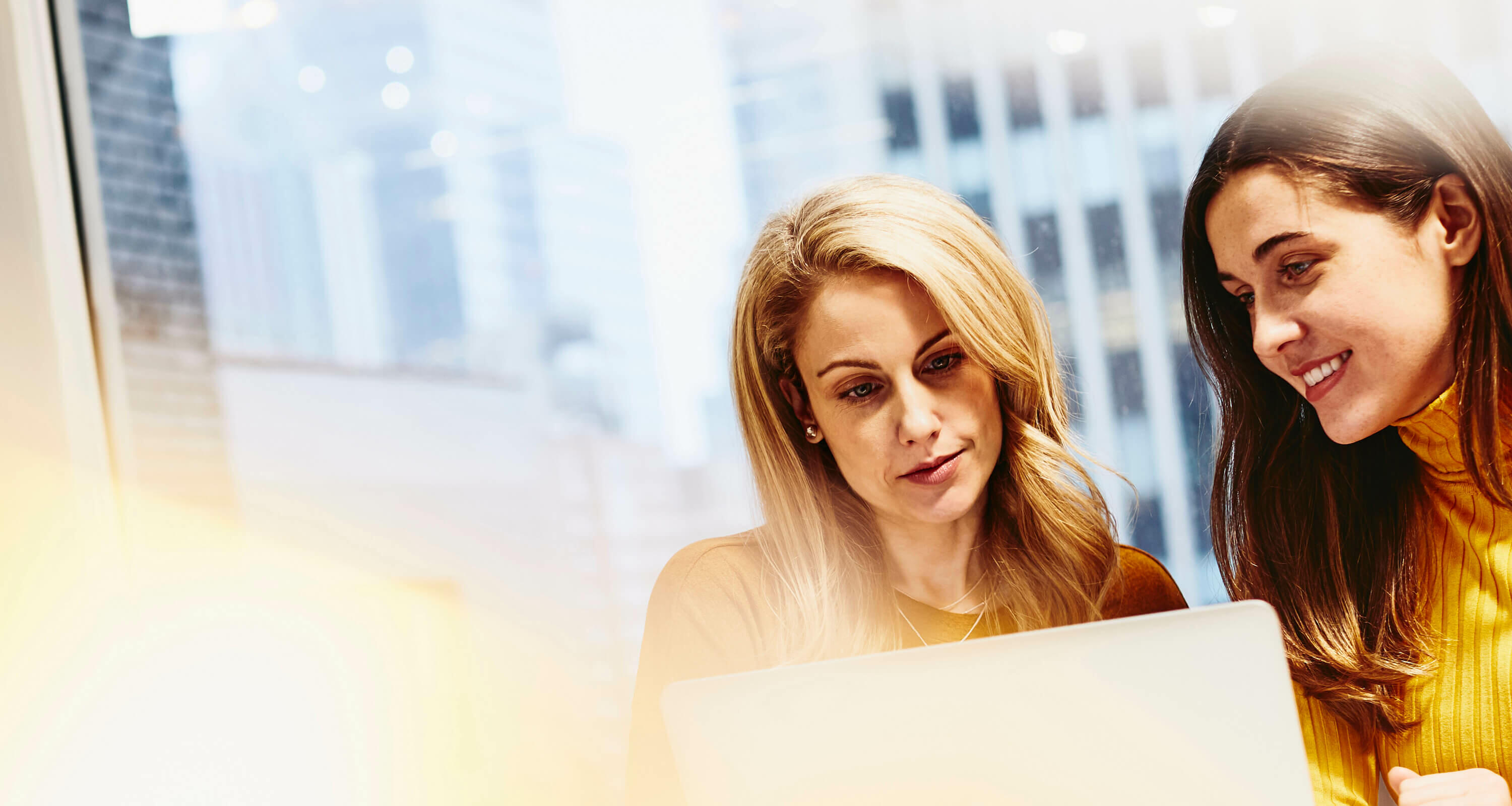 females sitting working on laptop