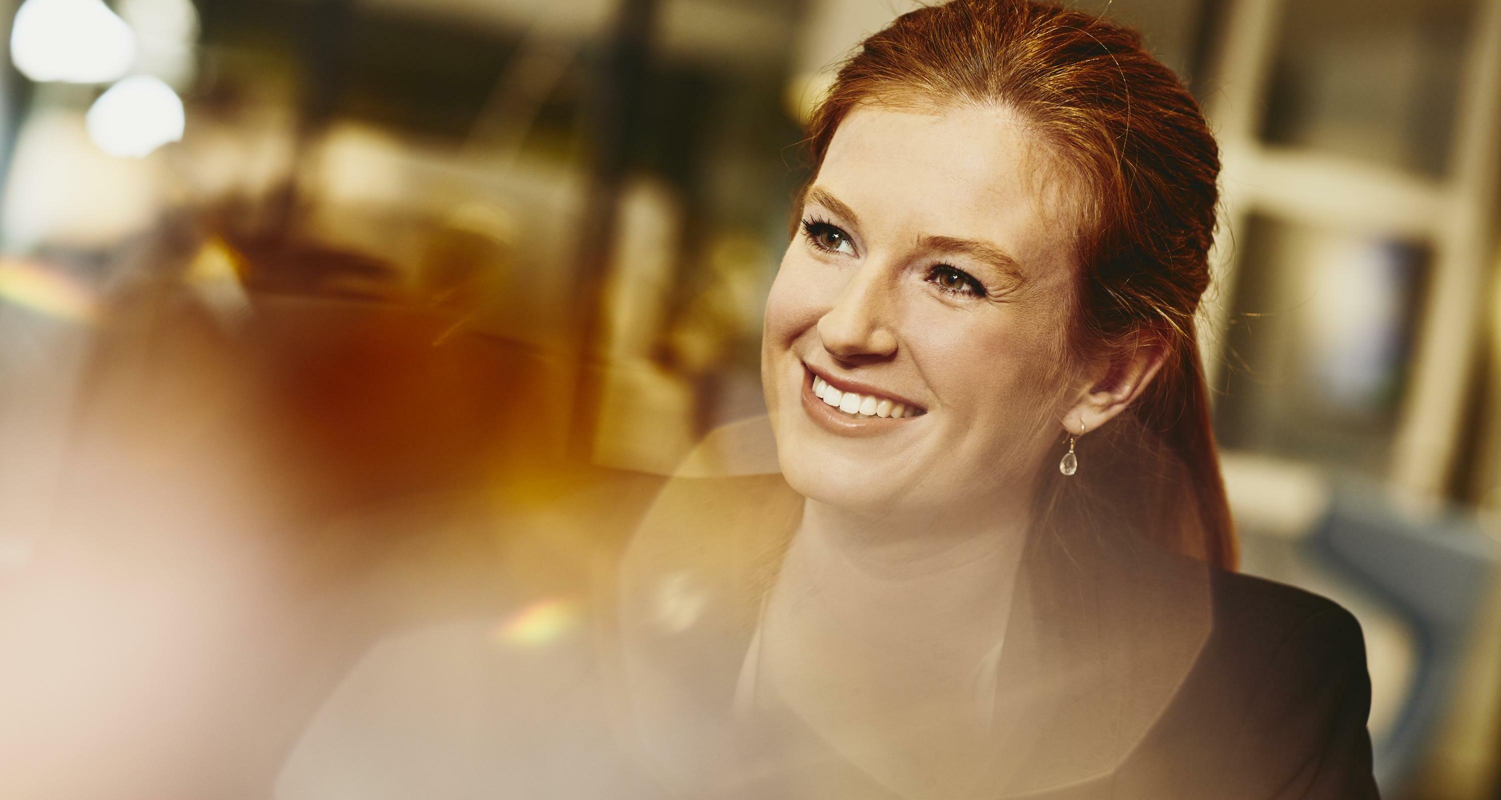 Business woman smiling. Primary colors: white and yellow.